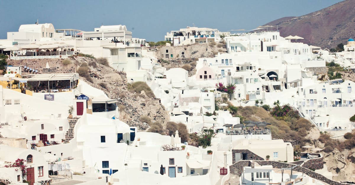 Scenic view of whitewashed houses in Santorini under clear skies.